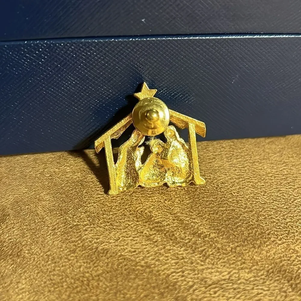 Live nativity gold brooch.